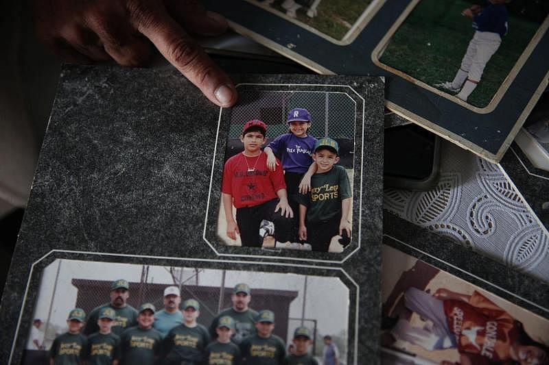 Theresa Martinez, 50, shows old photographs of her kids in Little League. Martinez was involved with the youth sports program in Bloomington for about three decades and is struggling to get youth sports started again.