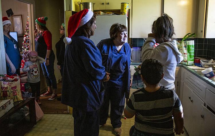 Margie Johnson, 60, and Janet Hilsabeck, 59, speak with Cindy Barrientes, who wipes a tear off her face in her kitchen. Her son, Jonathan Sanchez Jr., 6, stands behind her. Johnson and Citizens Medical Center’s Birth Center colleagues collected and delivered household items, Christmas presents and more to the family.