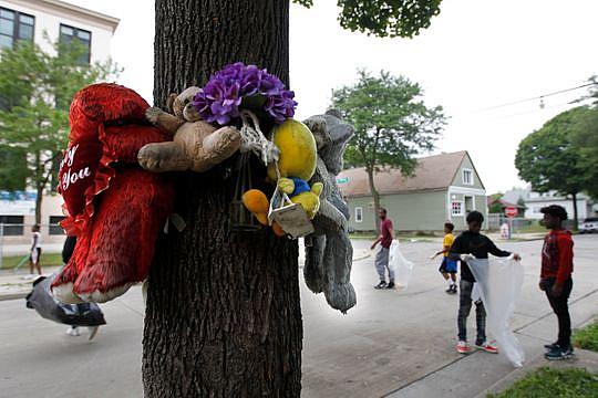 Boys from the "We Got This" summer program pick up trash near a memorial for Marvin Thomas, whose death sparked the "We Got This program at North 9th and West Ring Street. (Photo: Angela Peterson/Milwaukee Journal Sentinel)