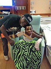 Erik "Doobie" Williams Jr. and Andre Lee Ellis take a picture in the hospital after the 4-year-old came out of a coma after he was was shot four times near North 10th and West Burleigh streets on Aug. 10. (Photo: Photo courtesy of Andre Lee Ellis)