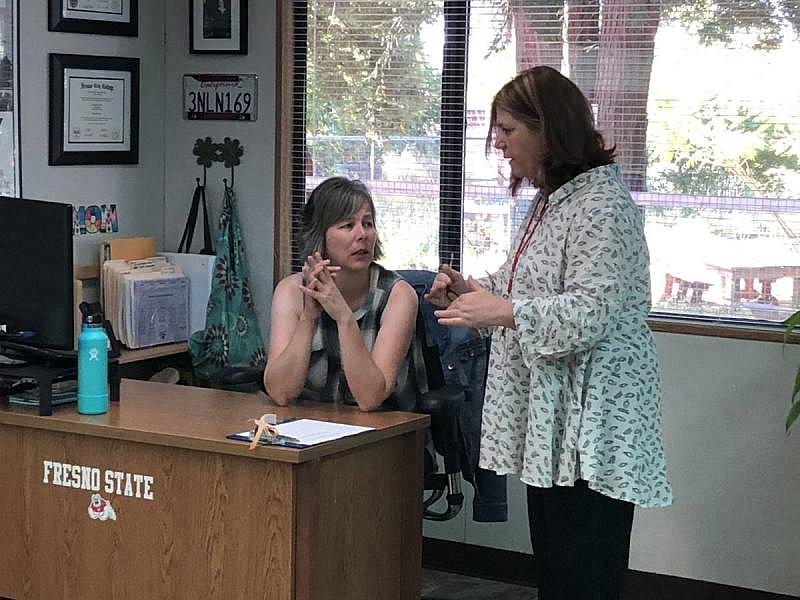 Honey Run Academy instructional aide Stacy Pew (left) speaks to Principal Dena Kapsalis at Honey Run Academy in June. The school has since burned down. (Laura Klivans/KQED)