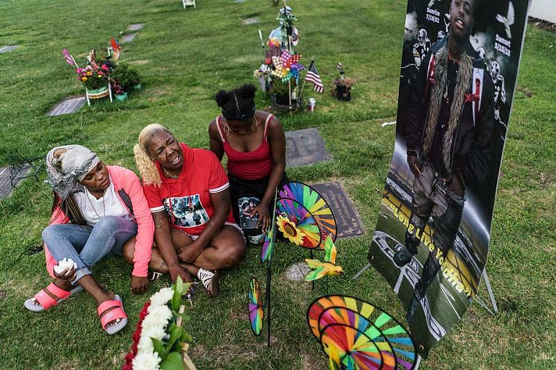 Brigitte Green is consoled at the burial site for her son, Monyae.