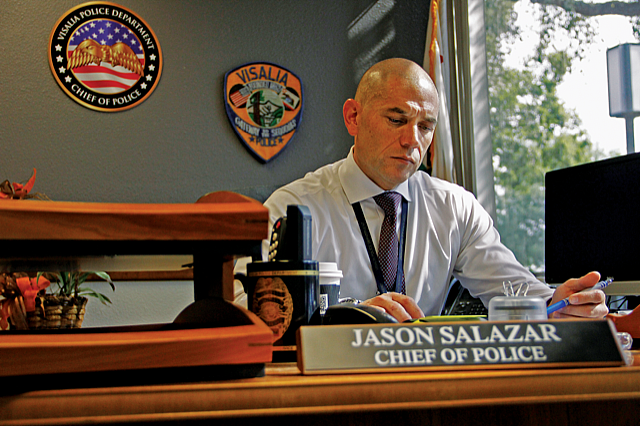Visalia Chief of Police Jason Salazar looks over paperwork in his office after discussing the merits of the HOPE team. Salazar says calls in regards to homelessness, the most public face of mental illness is Visalia, grew by 900 percent between 2007 and 2017. (Photo via Paul Myers)