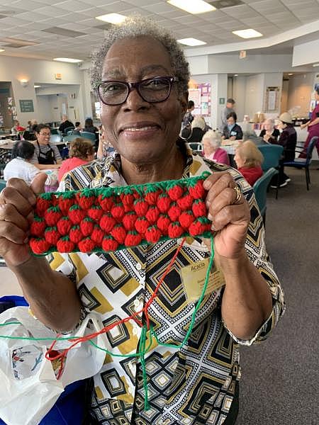 Lynette Quan Soon, 76, is a mother of seven. She proudly shows her crochet strawberries and other crafts that she makes. (Photo by Michelle Faust Raghavan/LAist)