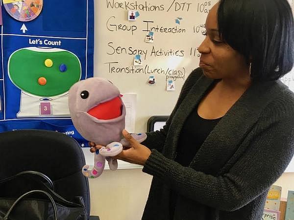Shoestrings program coordinator Crystal Hawkins shows off "Huggtopus," a plush toy in the Kimochis series. Kimochis (which means "feelings" in Japanese) come with a curriculum to help kids better deal with difficult feelings and challenging behaviors. (CREDIT LEE ROMNEY / KALW)
