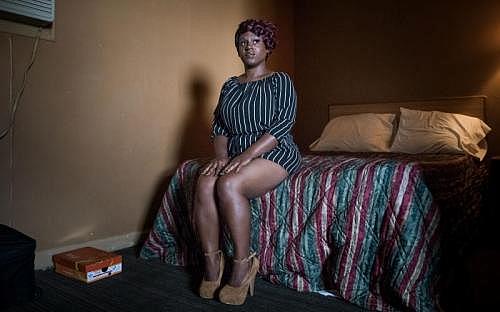 Ashley Peterson sat on her bed inside her room at the Airway Motel in Atlanta. (MYKAL MCELDOWNEY/INDYSTAR)