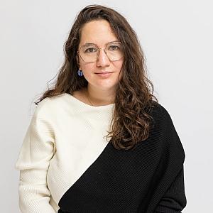 Person in black and white top with glasses and brownish
