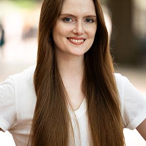 Person in off-white top with long brown hair