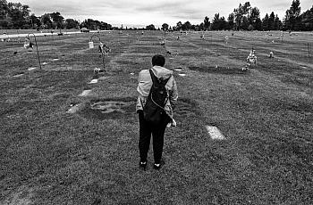 Black and white picture of a person in a graveyard