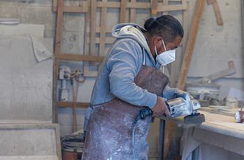 Person with a mask on using a power tool