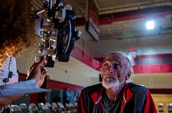 A man takes a vision test for a new pair of glasses at a remote-area mobile dental and medical clinic.