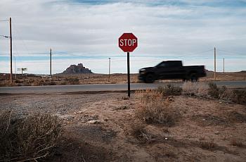 A truck passing by stop sign