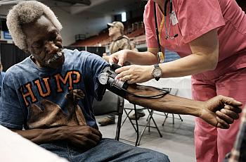 Healthcare worker checking blood pressure of a person