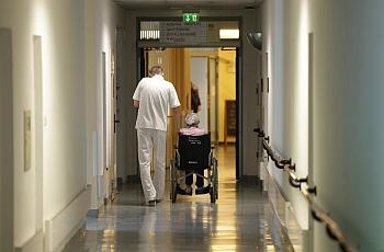 Person walking alongside someone in a wheelchair