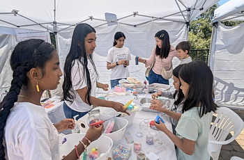 Young Desi youth volunteers work with children on an art project