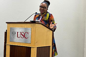 Journalist Akilah Johnson talks at a podium.
