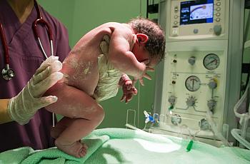 Healthcare worker holding a new born baby