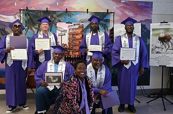 Six graduates in purple gowns hold up their diplomas