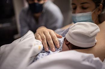 A mother carrying her baby in hospital bed