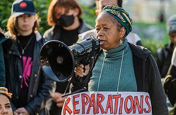 A black woman protesting using a microphone