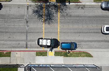 An aerial view of a deputy sheriff pulling over a driver in front of a school