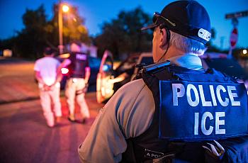 A police wearing ICE jacket 