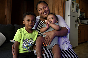 Person holding 2 children