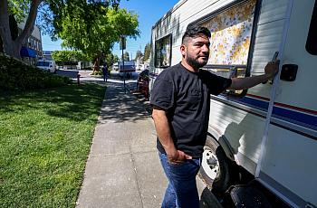 A person standing rear an RV