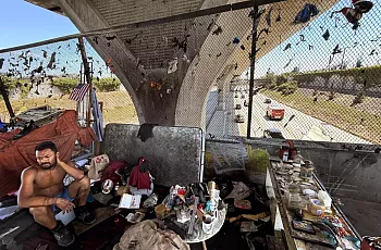 A men sits at a row of encampments