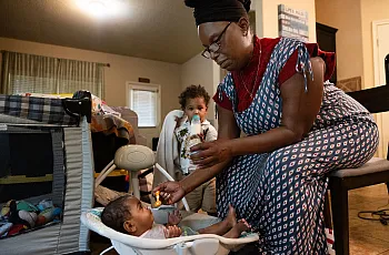 A person feeding a baby with a spoon