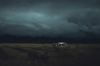 Scenic image of a home under cloudy dark sky