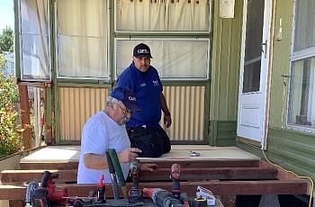 2 people  standing behind power tools