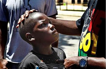 An adult consoling a child by stroking their head