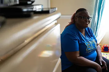 Person in blue top sitting in a room