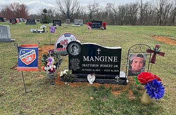 Grave of a player with his school's football fc flag and bouquet of flowers