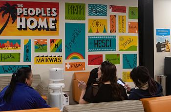 Three women wait in the colorful waiting room of UAII in Echo Park, Los Angeles