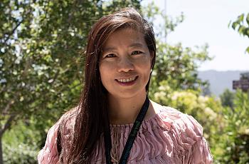 Person in pink top standing outdoors