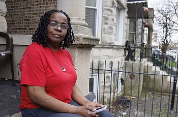A women sitting by a house 