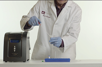 A lab technician works with a cocci sample to be used in a new testing instrument developed by DxNA LLC. that promises rapid, accurate detection.The specimen would be inserted into the machine, pictured to the left, and a diagnosis would be determined in about two hours. CREDIT: DxNA LLC
