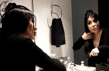 Person doing makeup in front of a mirror