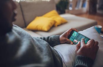 Person holding a mobile phone with a game betting screen on