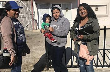 Tres mujeres de pie juntas con un bebé.