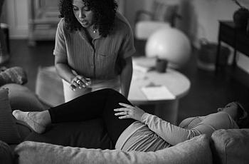 One person sleeping on couch other standing near them