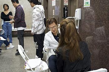 Person sitting in front of someone in a white coat