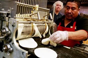 Brigham Young University professor Michael Dunn, left, works with Rancho Markets’ Jorge Morales to make tortillas fortified with folic acid in Provo, Utah. Dunn is conducting experiments that could lead the Food and Drug Administration to allow fortification of corn masa — a staple grain in Hispanic diets. (Erika Schultz / The Seattle Times)