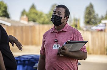 Fresno County STD investigator Hou Vang speaks with a patient to inform them of their diagnosis in July 2022.