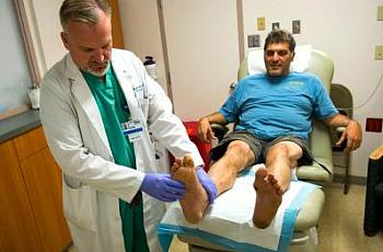 Dr. Eric Espensen checks the legs and feet of Paul Vinci at the Amputation Prevention Center.