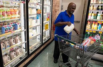 A customer buys a gallon of milk in the Cash Saver grocery store on Wilson Avenue. Sept. 25, 2018
