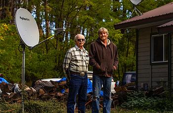  Outside their home in Keller, Ferry County, Marshel Sumerlin, left, and his son, Lee, have satellite dishes that Sumerlin has u