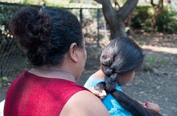 Victoria braids her daughter's hair after taking a shower at Hope's Corner. Photo by Ana Sofia Amieva-Wang
